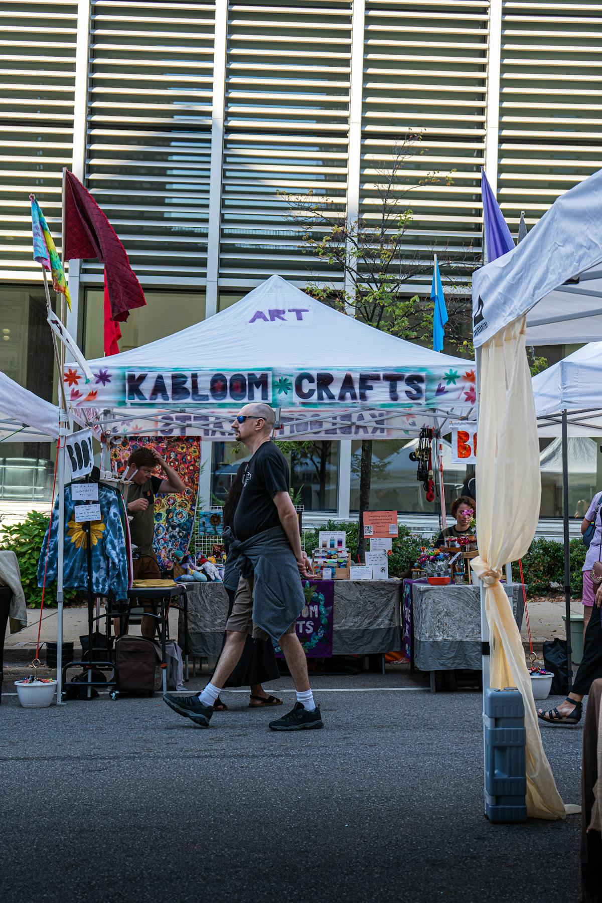 Colorful artisan booth display at an outdoor market with crafts and vendors