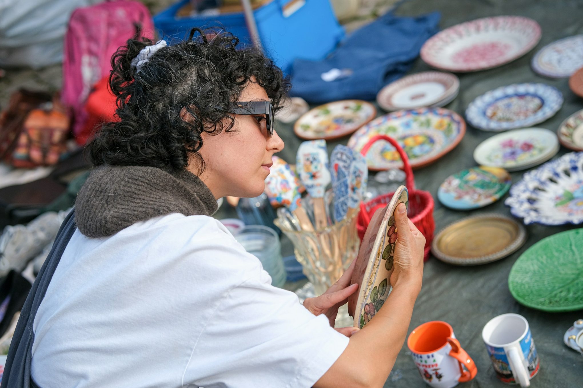 woman examining pottery flea market